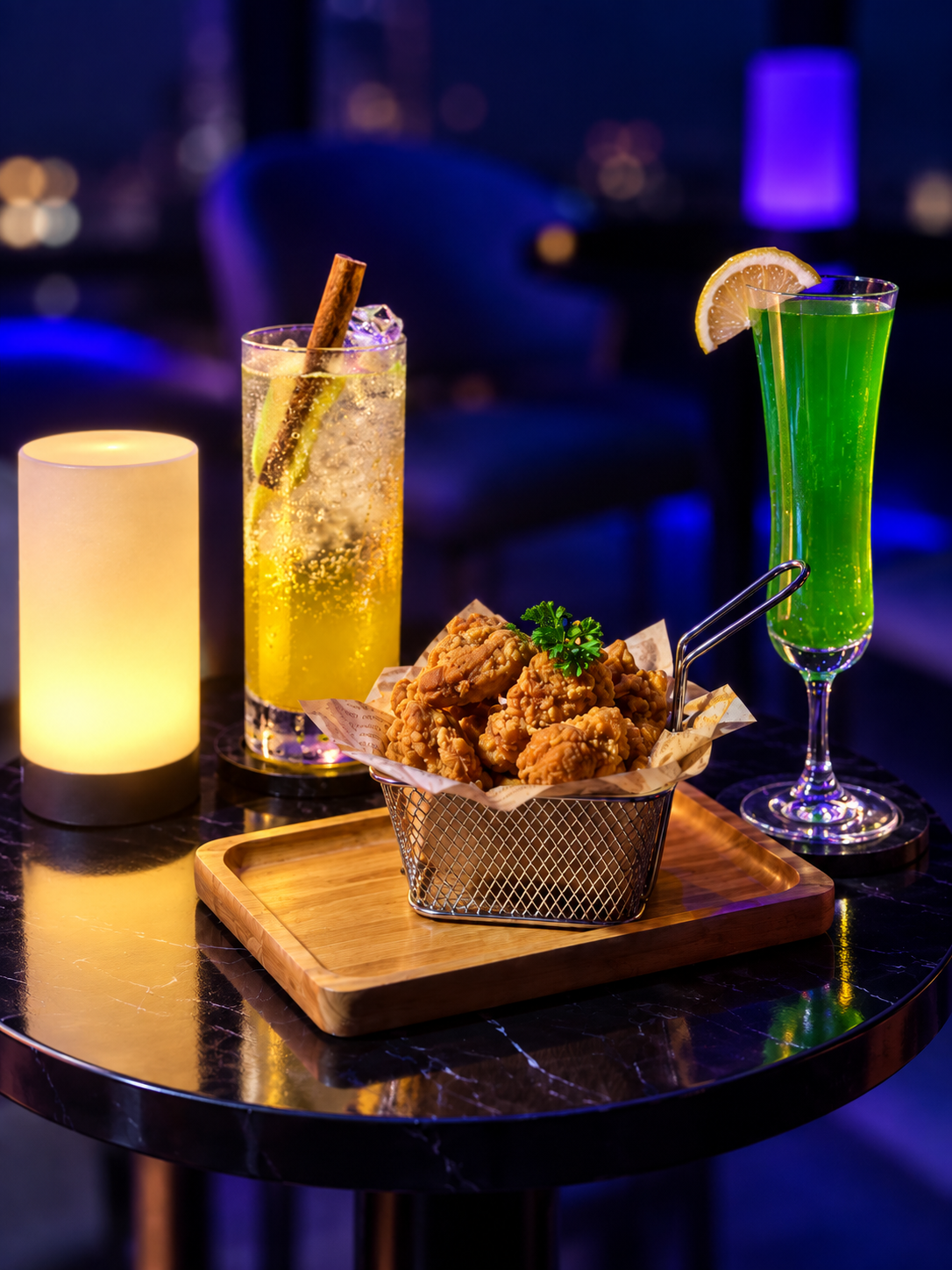 Cocktails and chicken karaage on a dark marble table