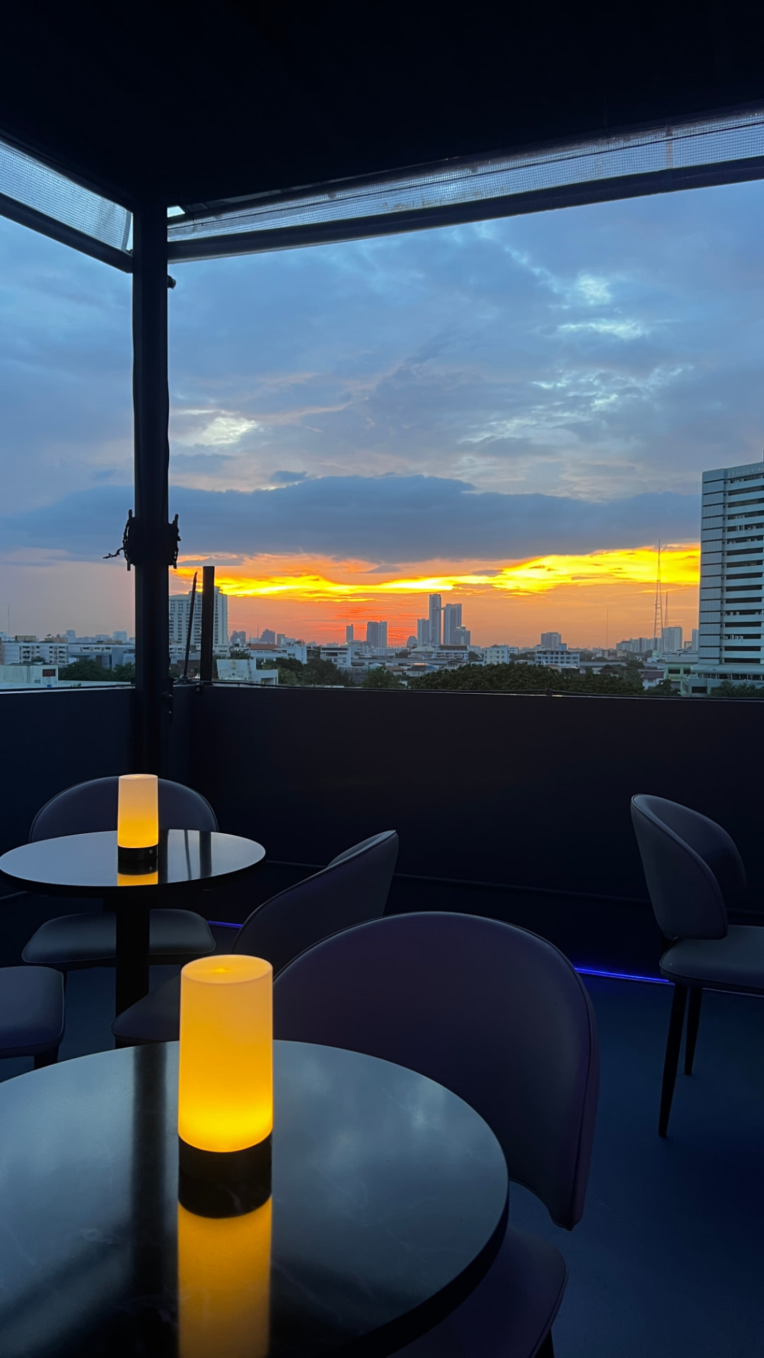 Rooftop tables at sunset with the Bangkok skyline in the background